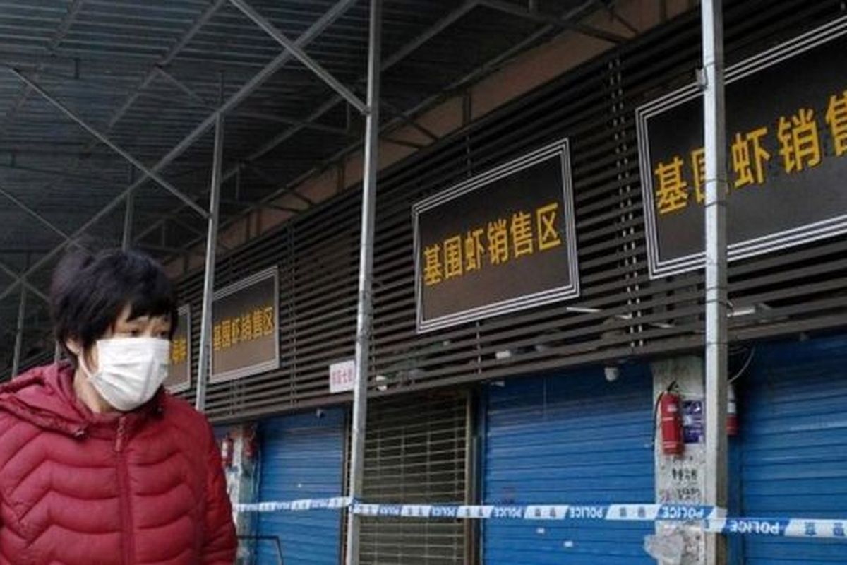 Seorang perempuan mengenakan masker melintas di kawasan pertokoan China. Sejak Desember 2019, China dilanda virus misterius mirip SARS. yang sudah menelan dua korban jiwa.
