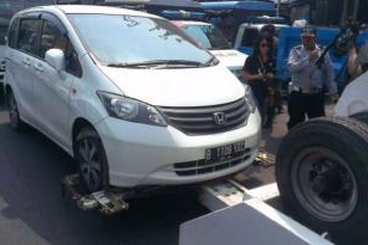 Petugas Dishub DKI menderek mobil yang parkir sembarangan di kawasan Tanah Abang, Jakarta Pusat, Senin (8/9/2014).