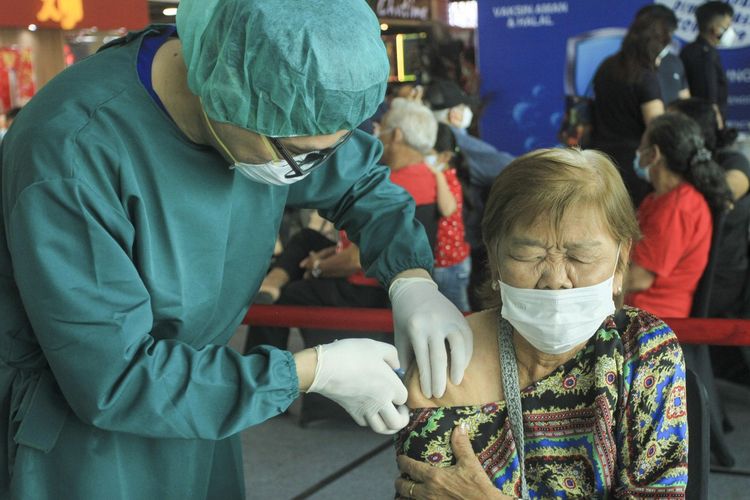 Seorang lansia sedang disuntik vaksin Covid-19 oleh seorang petugas medis. Sebelumnya, Pemerintah kota Palembang membuka Vaksinasi massal untuk lansia yang berusia 60 tahun ke atas di mall Palembang Icon (Picon), Selasa (16/3/2021). Vaksinasi ini diikuti oleh ratusan lansia yang telah mendaftar secara online.