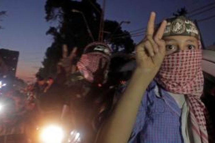 Dua orang bocah Palestina di Jalur Gaza menutupi wajah mereka sambil mengacungkan dua jari pertanda kemenangan saat ikut merayakan gencatan senjata dengan Israel pada Agustus 2014. Dalam konflik panjang antara Israel dan Palestina, bocah-bocah negeri itu kerap menjadi korban.