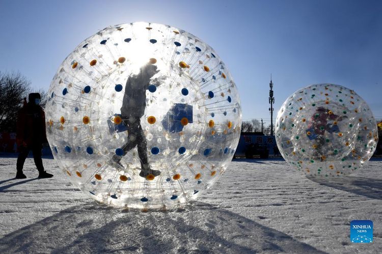  Pengunjung bermain di dalam balon udara di lapangan salju di Taman Yuanmingyuan di Beijing, China, (30/12/2021).  Istana Musim Panas Lama, atau Yuanmingyuan, mengumumkan pada hari Kamis bahwa mereka akan mengadakan festival es dan salju yang dibuka sekitar hari Tahun Baru pada tahun 2022 dan berlangsung hingga Februari untuk menyambut Olimpiade Musim Dingin Beijing 2022.