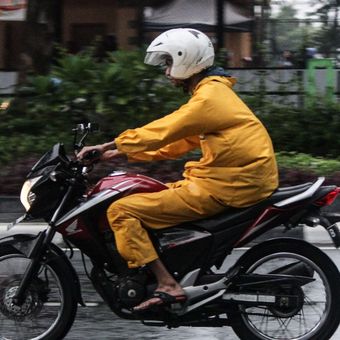 Pengendara sepeda motor mengenakan jas hujan saat terjadi hujan di Jalan Katedral, Sawah Besar, Jakarta Pusat, Minggu (22/12/2019). Badan Meteorologi, Klimatologi, dan Geofisika (BMKG) memberikan informasi dini cuaca ektrem yang akan melanda sejumlah wilayah di Indonesia pada hari Minggu (22/12/2019), dan Senin (23/12/2019).