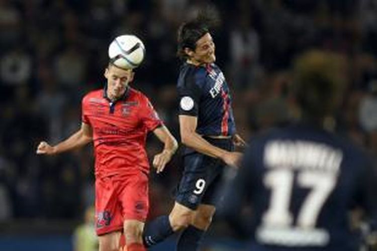 Striker Paris Saint-Germain (PSG), Edinson Cavani saat berebut bola dengan pemain Ajaccio, Alexandre Coeff, pada lanjutan Ligue 1, Minggu (16/8/2015). 
