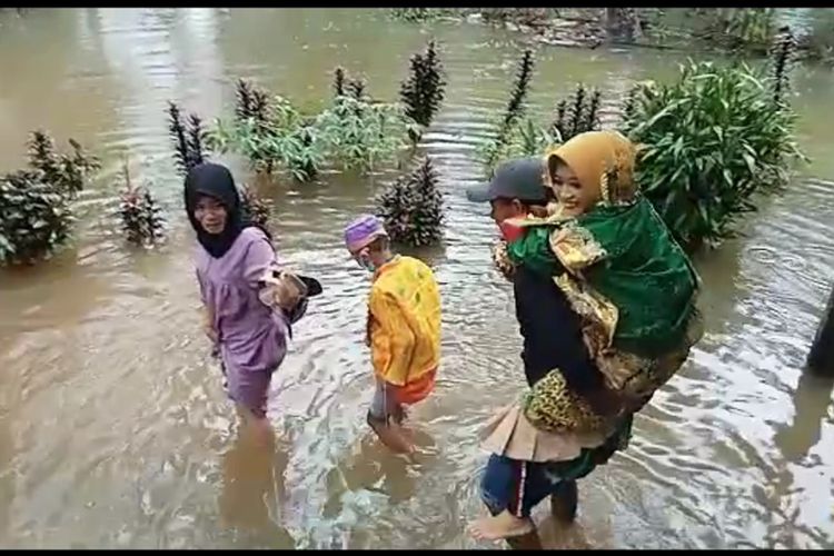 Viral, Menikah di Tengah Banjir Keluarga Mempelai Saling Gendong