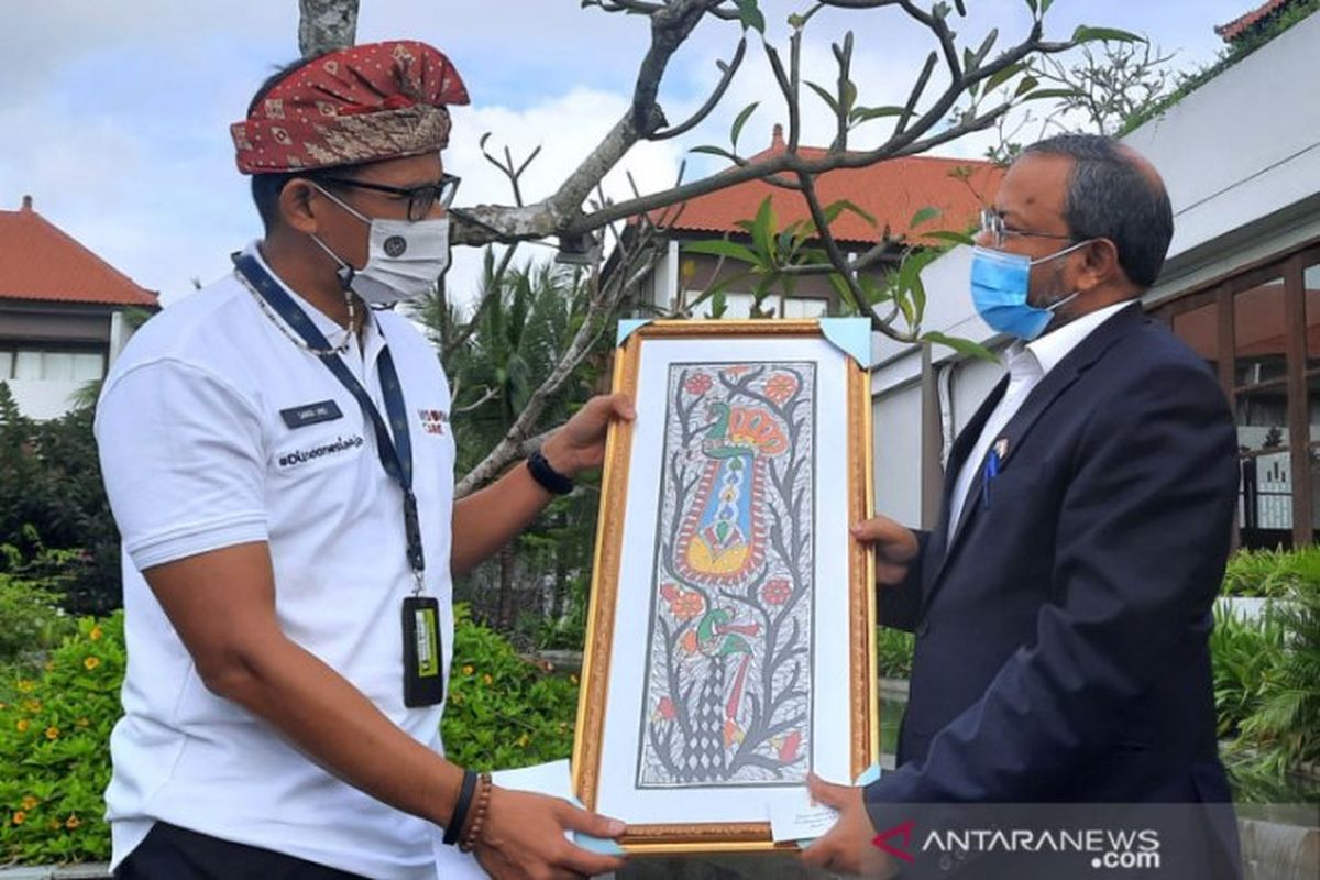 Minister of Tourism and Creative Economy, Sandiaga Salahuddin Uno, hands a souvenir to Indian Ambassador to Indonesia, Shri Manoj Kumar Bharti, in Badun on Wednesday, March 17. 