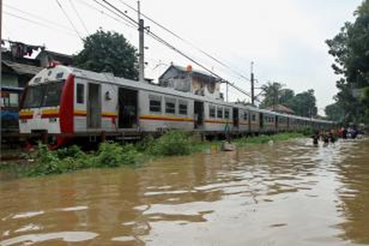 Kereta rel listrik (KRL) yang hendak melintas di Bukit Duri, Jakarta Selatan, terpaksa berhenti karena banjir hingga setinggi satu meter, Senin (13/1/2014). Sejumlah wilayah di Jakarta terendam banjir akibat curah hujan yang tinggi dan air kiriman dari Bogor. TRIBUNNEWS/HERUDIN