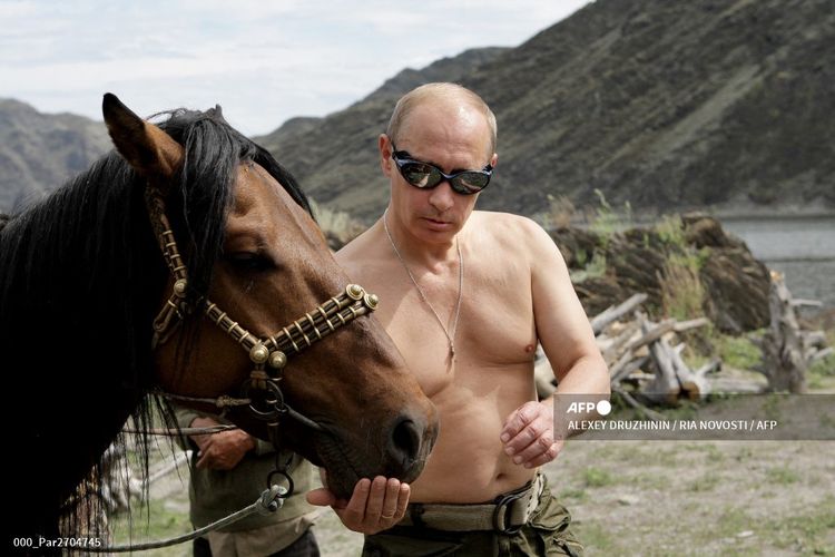 Presiden Rusia Vladimir Putin berfoto dengan seekor kuda saat berlibur di kota Kyzyl di Siberia Selatan pada 3 Agustus 2009. 