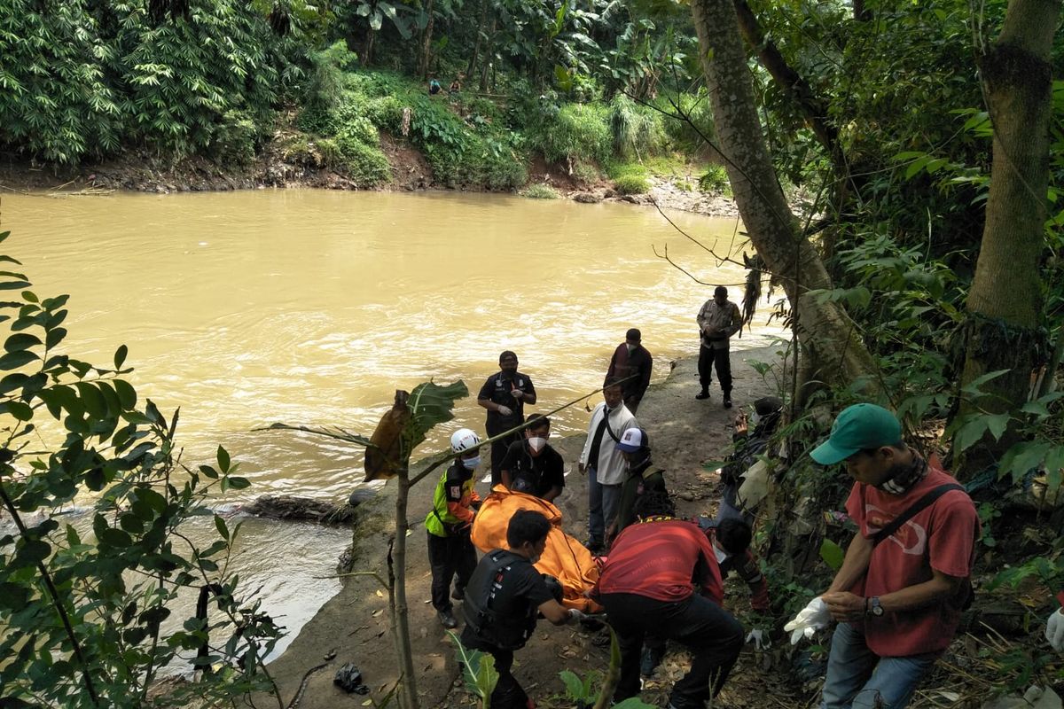 Warga setempat bersama polisi sedang mengevakuasi korban penemuan mayat di kali ciliwung, Kemiri Muka, Beji, Depok, Senin (17/1/2022).