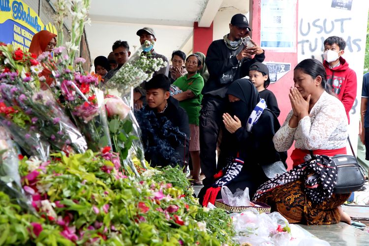 Seorang ibu beragama Hindu berdampingan dengan ibu yang beragama Islam berdoa pasca tragedi yang terjadi pada pekan ke-11 Liga 1 2022-2023 seusai pertandingan bertajuk Derbi Jawa Timur, Arema FC melawan Persebaya Surabaya di Stadion Kanjuruhan Kepanjen, Kabupaten Malang, Jumat (7/10/2022) siang.