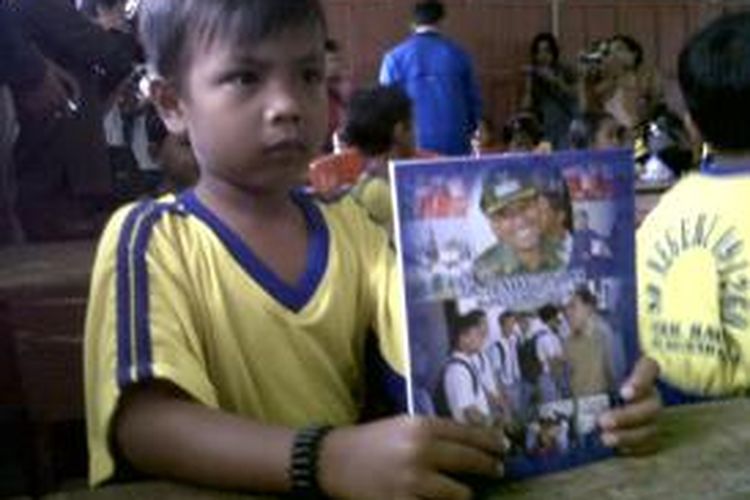 Salah seorang anak saat menerima buku tukis dari Bupati Simalungun JR Saragih, Jumat (6/9/2013).