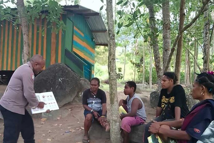 Aipda Fredrik Bay (53), terlihat mengajarkan mama-mama di halaman terbuka, sambil memegang buku pelajaran di Toladan, Kelurahan Sentani Kota, Distrik Sentani, Kabupaten Jayapura, Papua, belum lama ini.