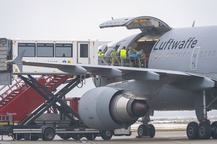 A Bundeswehr aircraft stands with its side flap open at the airport in Memmingen, Germany, Friday, Nov. 26, 2021. The German air force Luftwaffe will begin assisting the transfer of intensive care patients from hospitals in Bavaria to northern German states. (Peter Kneffel/dpa via AP)