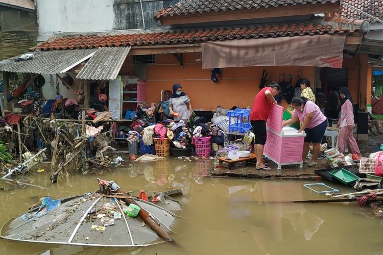 Sejumlah penyintas banjir membersihkan pakaian dan perlengkapan rumah tangga di Kampung Tugu, Baros, Sukabumi, Jawa Barat, Sabtu.(19/2/2022).