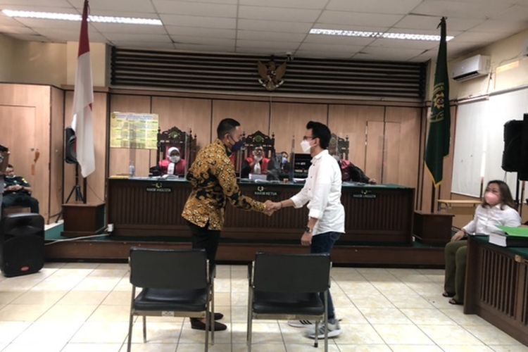 Adam Deni dan Ahmad Sahroni berjabat tangan, di PN Jakarta Utara, Rabu (6/4/2022).