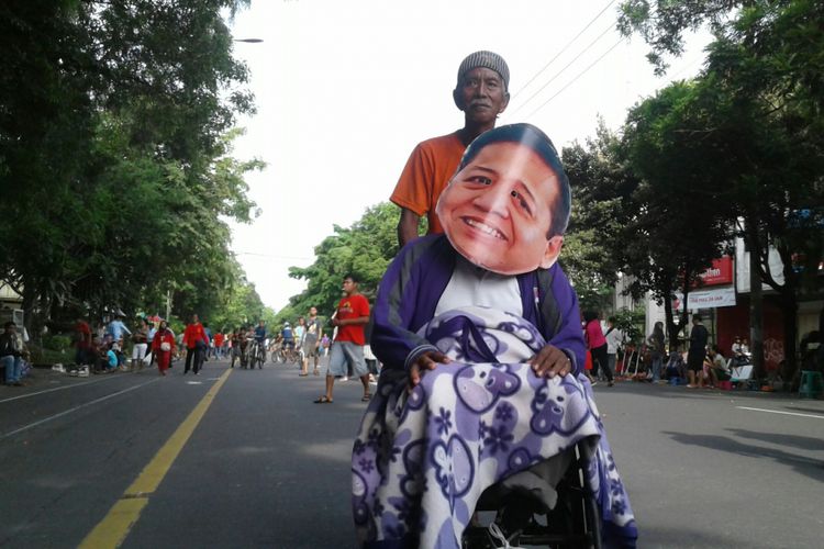 Aksi warga Solo memakai foto wajah Setya Novanto di CFD Solo, Minggu (20/11/2017).