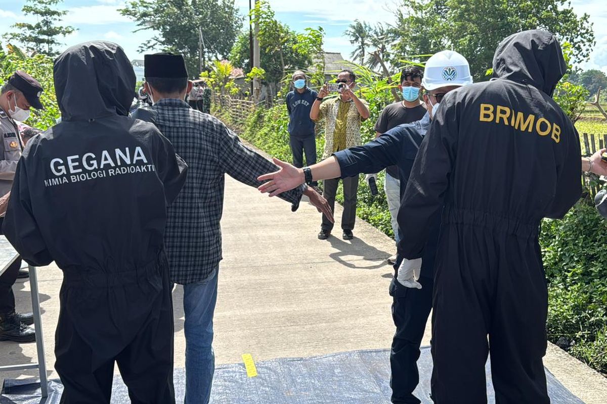 Petugas memeriksa warga yang direlokasi dari zona merah Cikande.