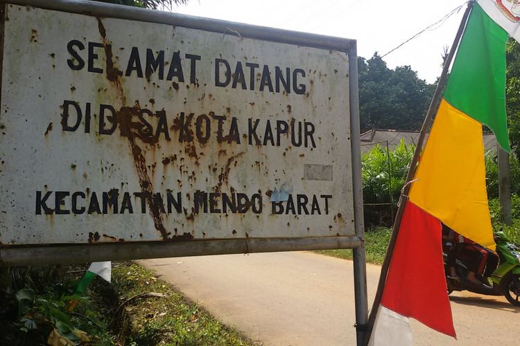 Plang nama yang terpasang di pinggir jalan saat memasuki Desa Kota Kapur, Kecamatan Mendo Barat, Kabupaten Bangka, Kepulauan Bangka Belitung.