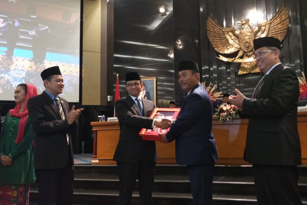 Ketua DPRD DKI Jakarta Prasetio Edi Marsudi menyerahkan berkas APBD DKI Jakarta sebesar Rp 89 triliun yang telah disetujui DPRD DKI kepada Gubernur DKI Jakarta Anies Baswedan dalam rapat paripurna di Gedung DPRD DKI Jakarta, Jumat (30/11/2018).