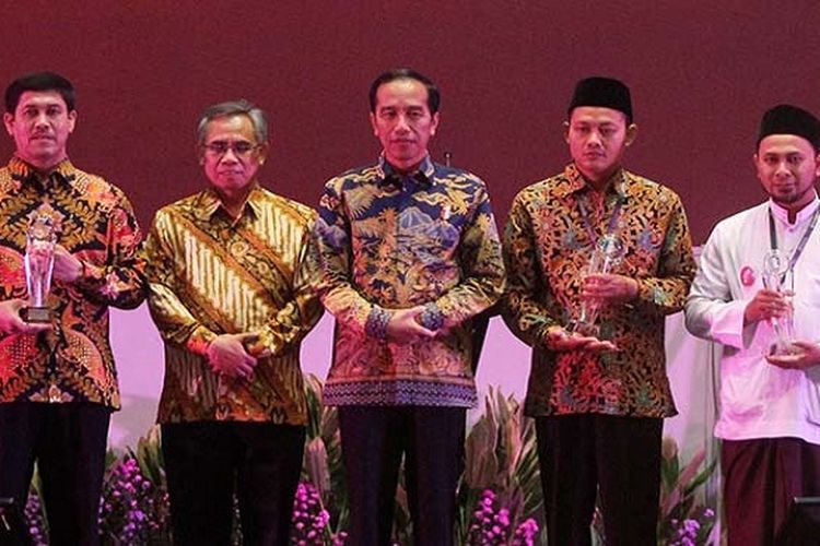 Presiden Joko Widodo dan Ketua Dewan Komisioner OJK Wimboh Santoso menyerahkan Tokoh ?Inspirator Inklusi Keuangan? kepada tokoh yang mendukung perluasan akses keuangan di Hotel Ritz Carlton, Pacific Place, Jakarta, Kamis (18/1/2018).