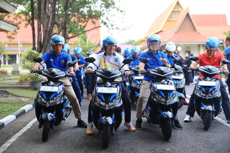 Gubernur Riau Syamsuar (tengah) bersama GM PLN Riau-Kepri Agung Murdifi (kiri) saat konvoi sepeda motor listrik di Kota Pekanbaru, Riau, Minggu (11/9/2022) pagi.