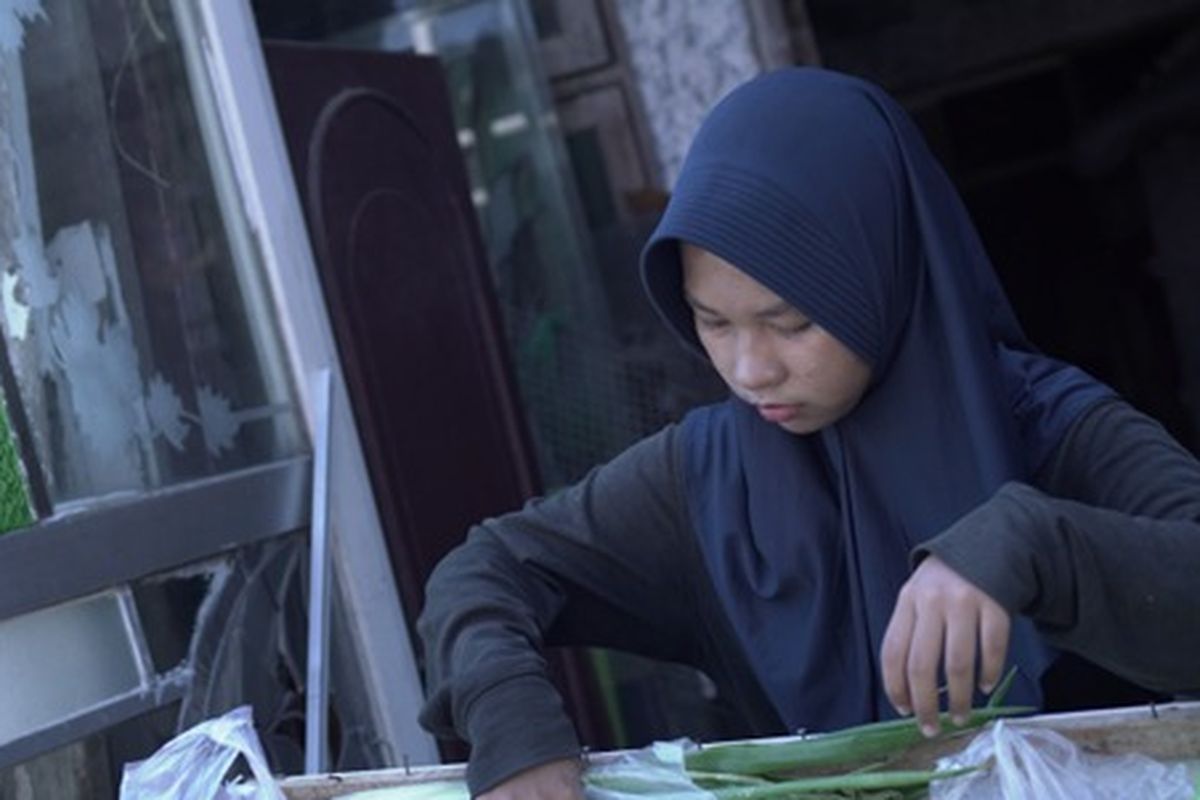 Terlihat, Linggas, remaja putri penerima manfaat Program Beasiswa YES yang diterima kuliah di Institut Teknologi Sepuluh Nopember (ITS), Surabaya. Ia sedang menata semua sayur dan bahan lainnya untuk dijual di depan rumahnya.