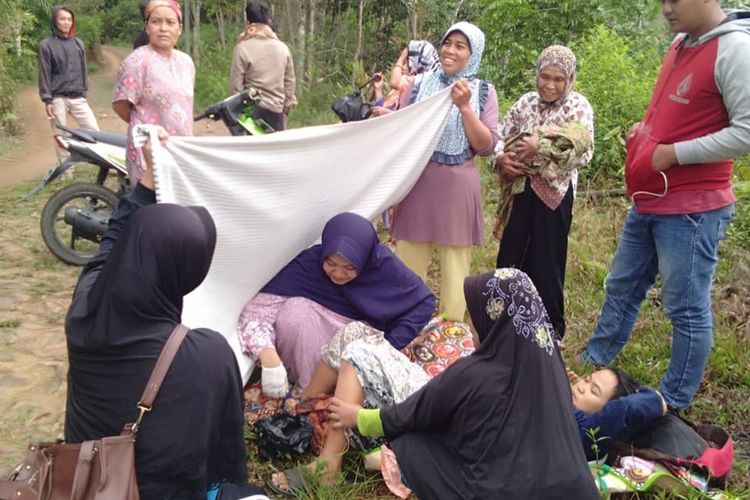 Warga membantu ibu hamil, Yati, warga Gunung Singkup, Kecamatan Langkaplancar, Kabupaten Pangandaran yang melahirkan di pinggir jalan, Jumat pagi (4/10/2019).