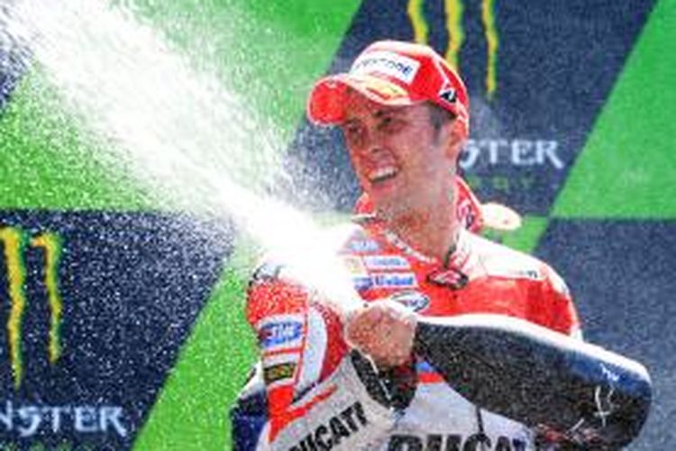 Pebalap Ducati asal Itaia, Andrea Dovizioso, menyemprotkan champagne saat merayakan finis ketiga GP Perancis di atas podium Sirkuit Le Mans, Minggu (17/5/2015).