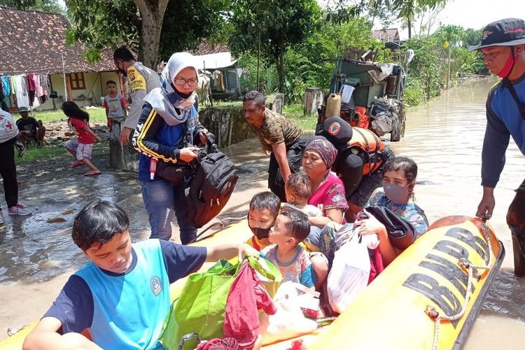 EVAKUASI—Petugas mengevakuasi warga yang terdampak banjir di Kabupaten Madiun setelah hujan lebat melanda kampung pesilat sejak Rabu (14/4/2021) malam hingga Kamis (15/4/2021) pagi.