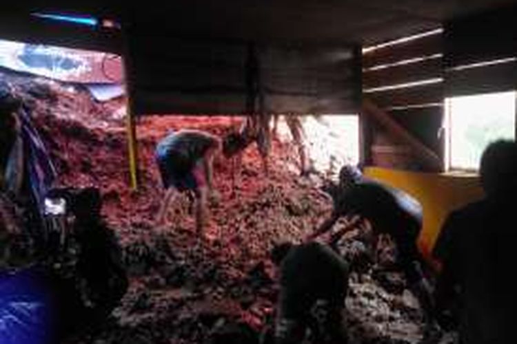 Sebuah rumah warga di kawasan Batu Merah mengalami kerusakan setelah tertimpa longsor, Minggu (31/7/2016). tampak warga tengah membersihkan material longsor dari dalam rumah tersebut 