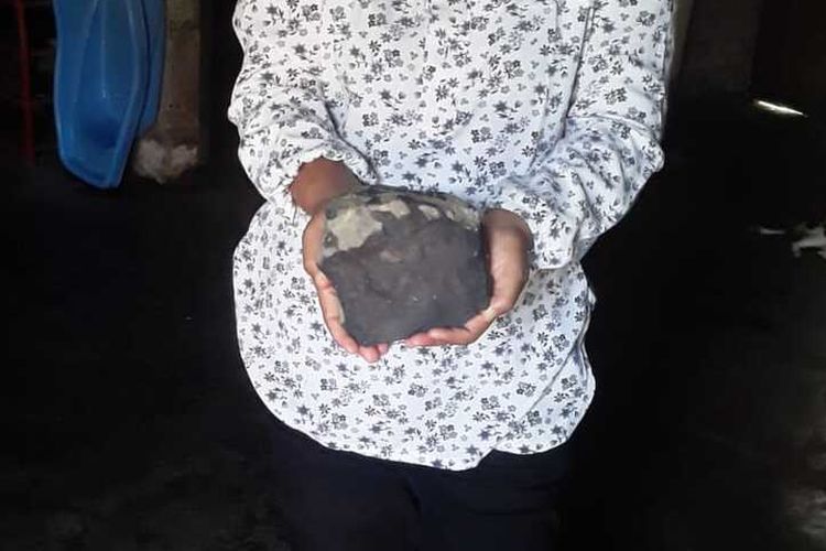 Isteri Josua Hutagalung (33) warga Dusun Sitahan Barat, Desa Satahi Nauli, Kecamatan Kolang, Kabupaten Tapanuli Tengah menunjukkan batu yang diduganya sebagai meteor setelah jatuh menimpa rumahnya, Sabtu (1/8/2020).