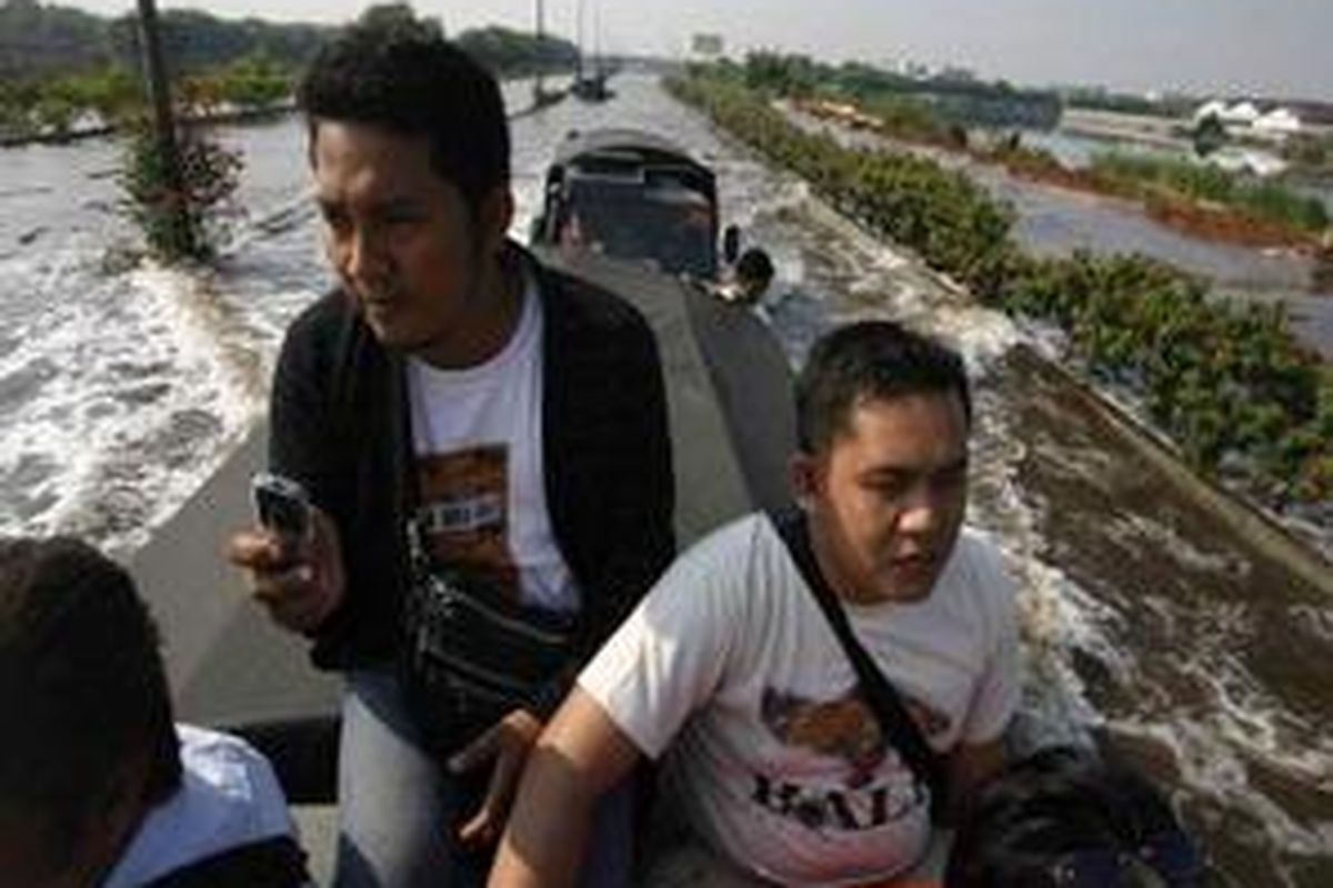 Jalan Tol Bandara Terputus Penumpang naik diatas truk polisi menembus genangan air di Jalan tol Sedyatmo, Tangerang, Provinsi Banten, Kamis (8/5). Jalan tol Sedyatmo menuju dan dari bandara Soekarno-Hatta di Km 26 -27 tergenang air hingga satu meter akibat jebolnya tanggul di Km 26,600 Kompas/Agus Susanto 
