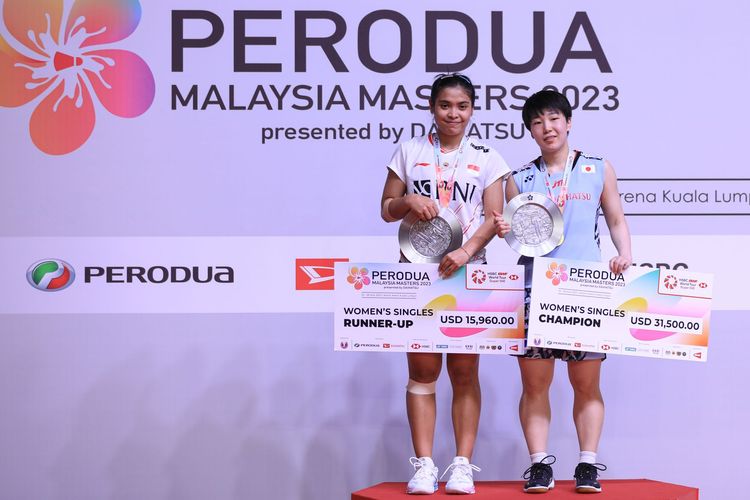 Pebulu tangkis tunggal putri Indonesia, Gregoria Mariska Tunjung, berpose di podium bersama Yakane Amaguchi usai final Malaysia Masters 2023 di Axiata Arena, Kuala Lumpur, Malaysia, pada Minggu (28/5/2023) sore WIB. Gregoria harus mengakui keunggulan Yamaguchi dengan skor 17-21, 7-21.