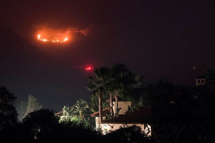 Kebakaran di perbukitan, belakang sebuah rumah, di Montecito, California, Sabtu (16/12/2017). (AFP/Robyn Beck).