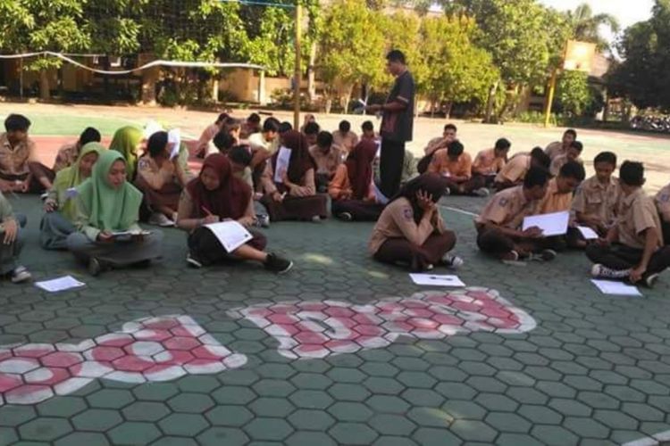 Foto puluhan siswa yang melaksanakan ujian di lapangan sekolah. Foto ini menjadi viral di medsos sebab status foto tersebut menyebutkan para siswa melakukan ujian di lapangan karena belum membayar SPP. 