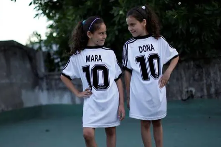 Mara dan Dona, dua bocah kembar yang namanya terinspirasi dari bintang sepakbola dunia Diego Armando Maradona, berpose dengan jersey mereka di Buenos Aires.