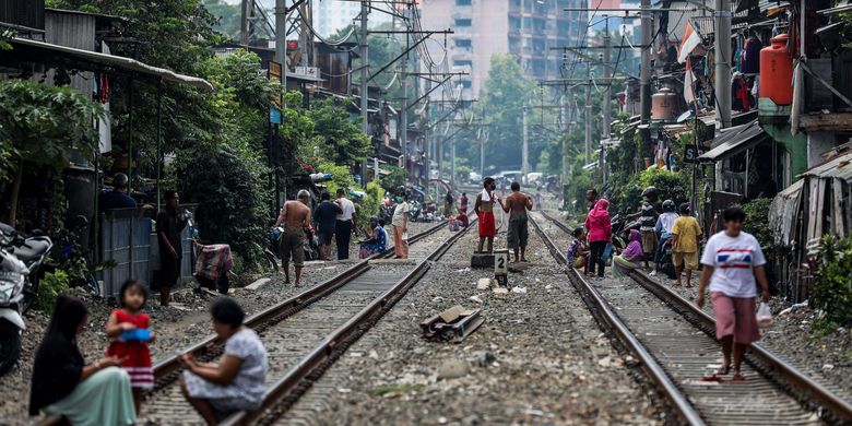 Warga berjemur di bawah sinar matahari di sekitar rel kereta Petamburan, Tanah Abang, Jakarta Pusat, Jumat (10/4/2020) pagi. Selain berolahraga, berjemur di bawah sinar matahari menjadi aktivitas rutin di tengah pandemi Covid-19 yang disebabkan virus corona SARS-CoV-2.