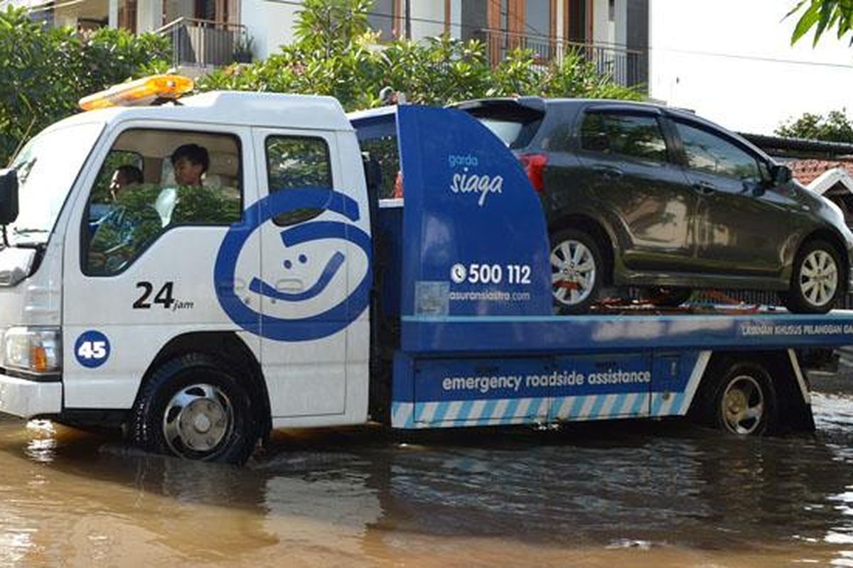 Mobil pelanggan diselamatkan oleh perusahaan Asuransi akibat banjir di Ibukota, Senin-Selasa (9-10/2/2015).