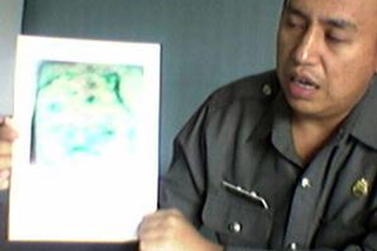 Kepal Kepolisian Sektor Metro Cakung Komisaris Yayat Popon memperlihatkan gambar kepala macan pada lengan kiri atas korban mutilasi, Jumat (3/10). Korban ditemukan di kolong tempat duduk bus Mayasari Bhakti, Senin (29/9).