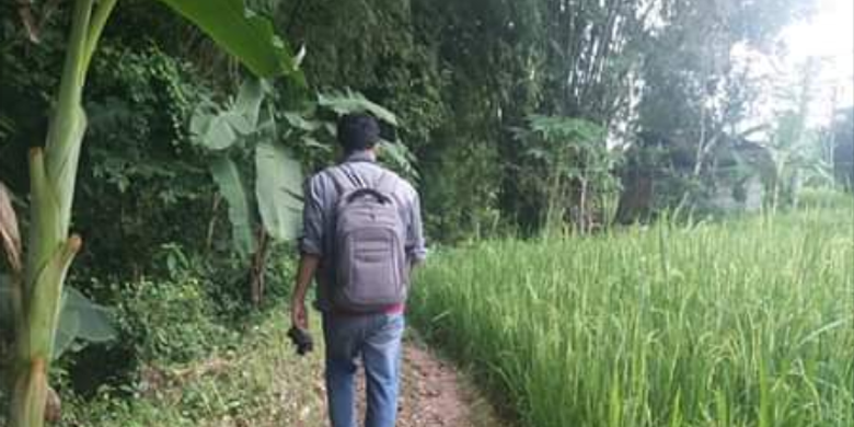 Avan menyusuri jalanan yang merupakan pematang sawah untuk mencapai rumah siswanya.