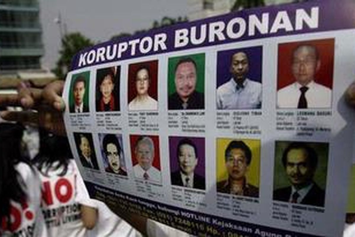 Poster koruptor yang menjadi buronan pemerintah Indonesia dibawa seorang aktivis antikorupsi dalam sebuah unjuk rasa di Jakarta. 