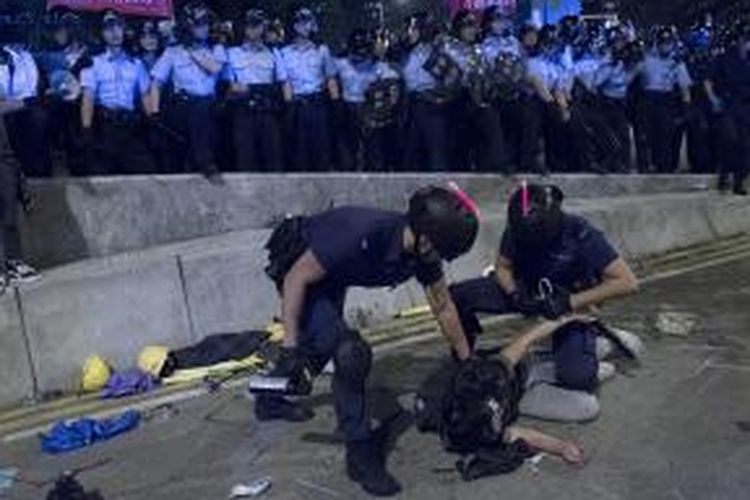 Polisi Hongkong melumpuhkan seorang pengunjuk rasa dalam bentrokan yang terjadi di pusat pemerintahan kota itu di distrik Admiralty, Senin (1/12/2014).