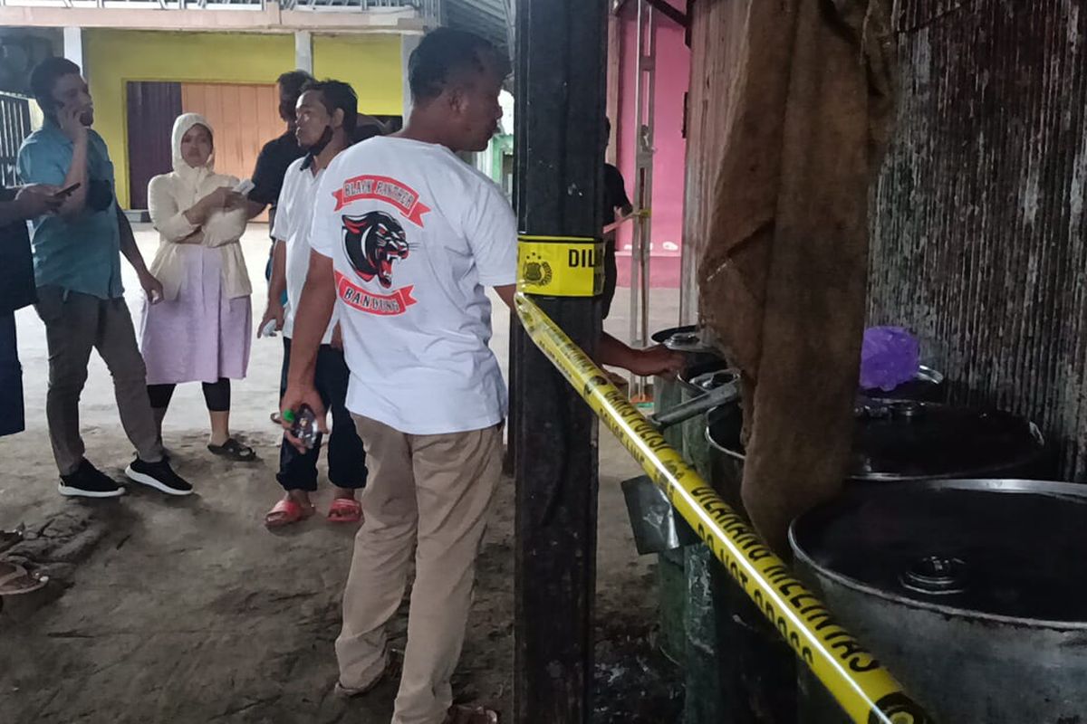 Petugas Satreskrim Polres Tanah Bumbu memberi garis polisi salah satu gudang yang diduga menimbun 4 ton minyak goreng curah, Selasa (16/3/2022). 