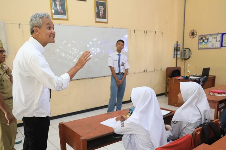 Gubernur Jawa Tengah Ganjar Pranowo saat masuk ke salah satu kelas di SMAN 1 Maos, Cilacap, dan bertanya tentang antikorupsi kepada para siswa, Senin (8/4/2019).