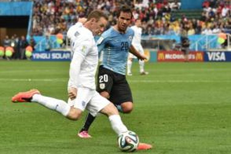 Striker Inggris, Wayne Rooney (putih), mendapat kawalan pemain Uruguay, Alvaro Gonzalez, pada laga Grup D Piala Dunia 2014 di Stadion Corinthians, Sao Paulo, Kamis (19/6/2014).