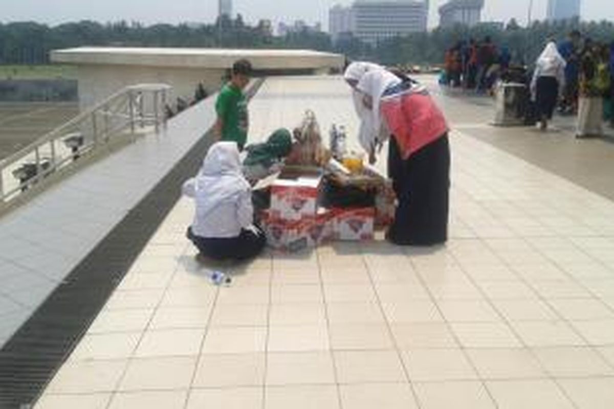 Pengunjung membeli dagangan PKL di area Tugu Monas, Minggu (20/4/2014).