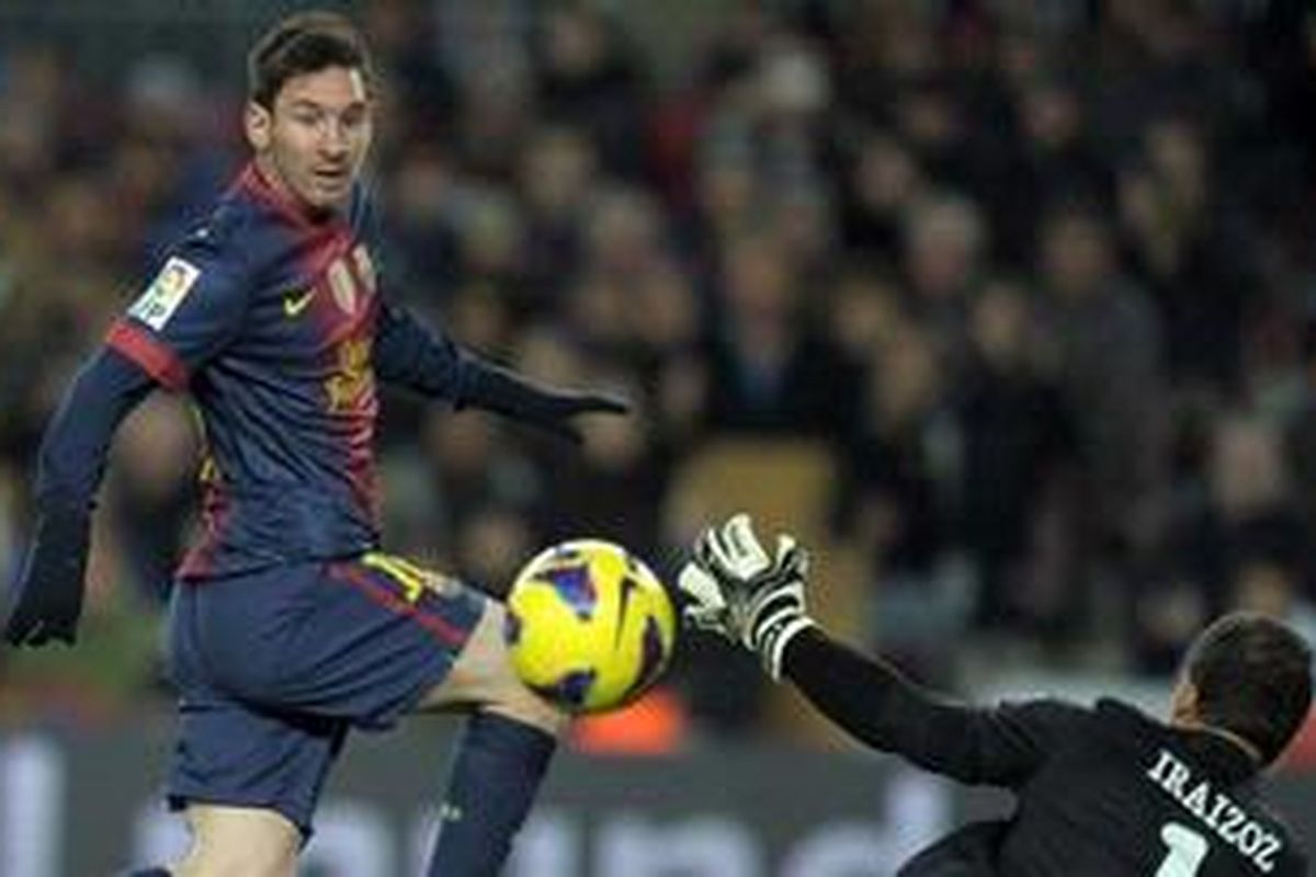 Striker Barcelona, Lionel Messi, menaklukkan kiper Athletic Bilbao, Gorka Iraizoz, untuk mencetak gol di Camp Nou, Sabtu atau Minggu (2/12/2012) dini hari WIB.