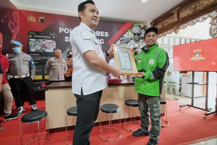 Pengemudi ojol, Umar (29) menerima sertifikat penghargaan dari Polrestabes Semarang yang diserahkan Kasatreskrim Polrestabes Semarang AKBP Donny Lumbantoruan, Rabu (14/12/2022).