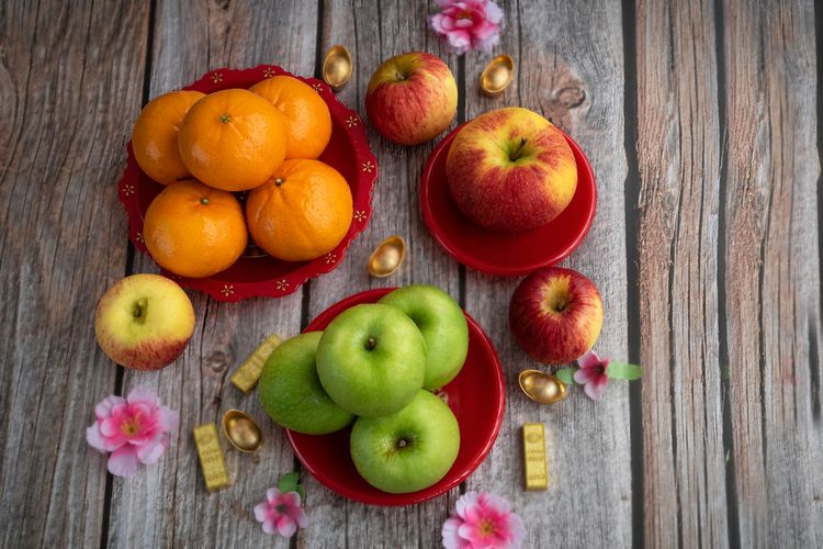 Ilustrasi buah jeruk dan apel yang merupakan buah khas Imlek. Buah-buahan ini dianggap membawa keberuntungan. 