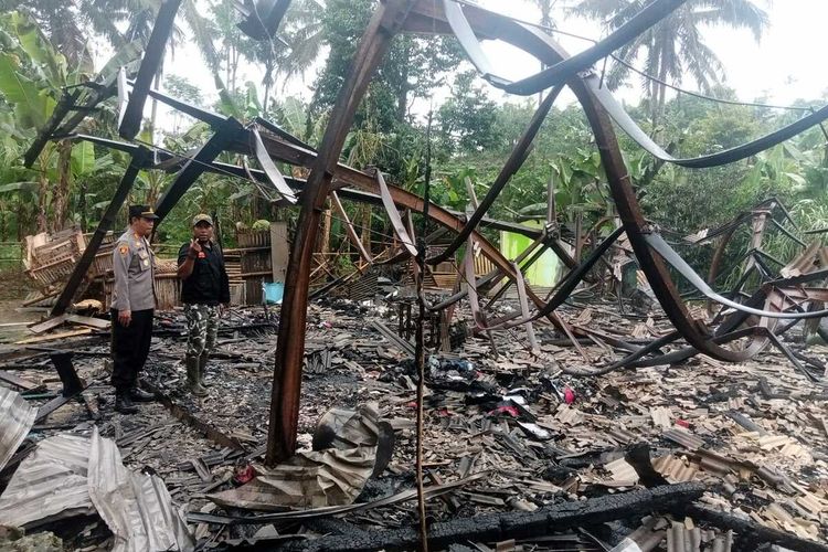 Kepala Polsek Jampangtengah AKP Usep Nurdin (kiri) mengecek lokasi kebakaran 6 unit rumah semi permanen yang merenggut 1 anak tewas di Desa Panumbangan, Kecamatan Jampangtengah, Sukabumi, Jawa Barat, Senin (26/12/2022).