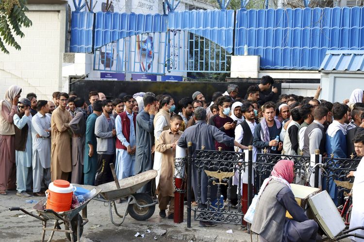 Warga Afghanistan menunggu dalam antrean panjang selama berjam-jam untuk mencoba menarik uang, di depan sebuah bank di Kabul, Afghanistan, Senin, 30 Agustus 2021.